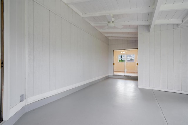 interior space with ceiling fan and wood walls