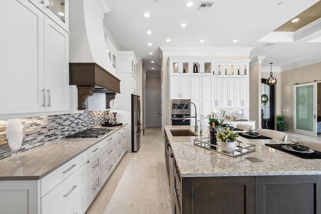 kitchen featuring ornamental molding, a large island, appliances with stainless steel finishes, and white cabinetry