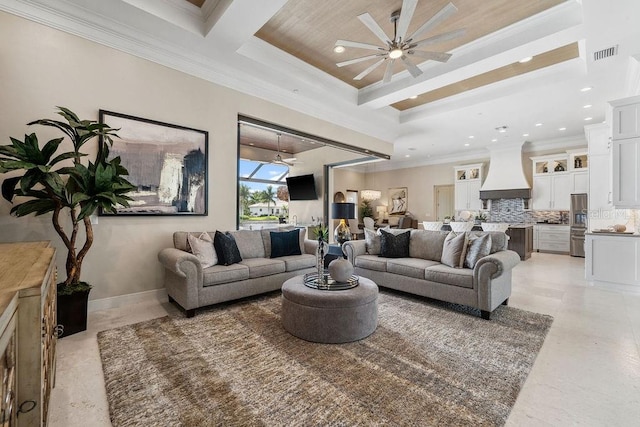 living room with crown molding, a tray ceiling, and ceiling fan