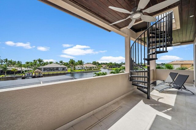 balcony featuring a water view and ceiling fan