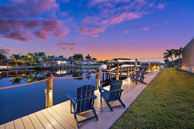 view of dock with a water view and a lawn