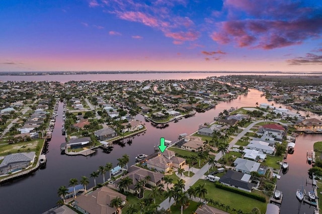 aerial view at dusk featuring a water view