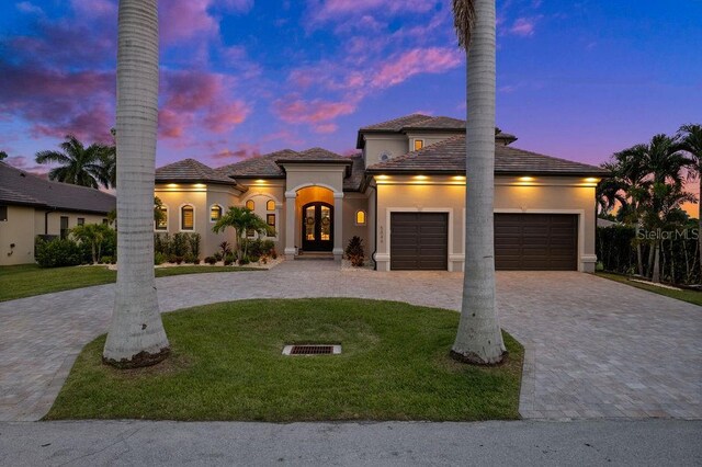 view of front of home with a garage and a yard