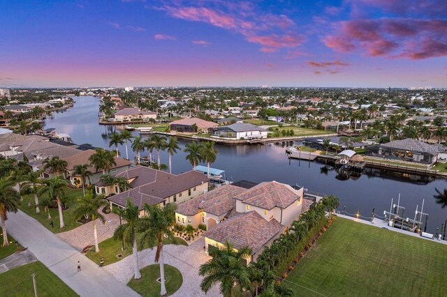 aerial view at dusk featuring a water view