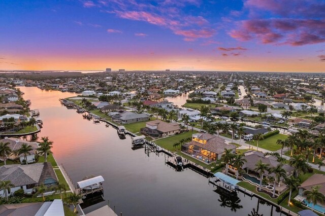 aerial view at dusk featuring a water view