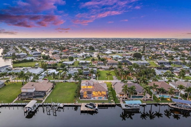 aerial view at dusk featuring a water view