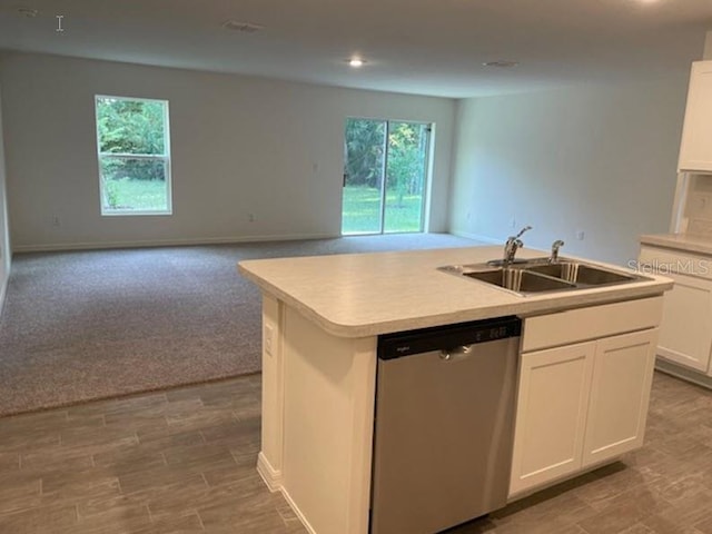 kitchen with white cabinets, sink, a center island with sink, carpet, and dishwasher