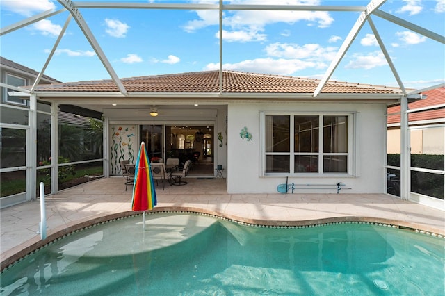 rear view of house featuring a patio, glass enclosure, and ceiling fan