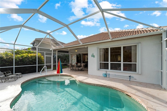 view of swimming pool featuring a patio area, ceiling fan, and a lanai