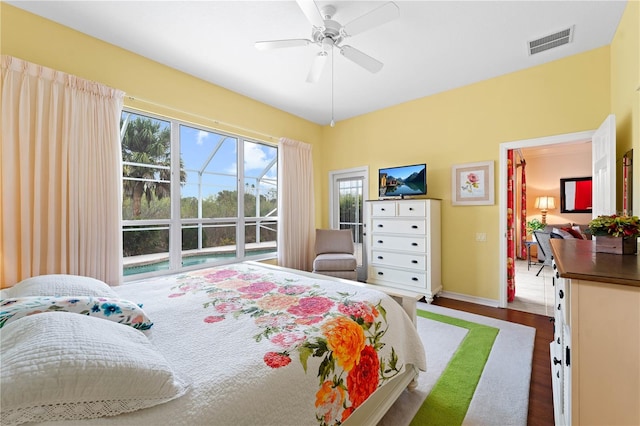 bedroom featuring hardwood / wood-style floors, ceiling fan, and multiple windows