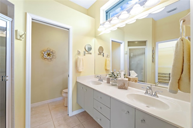 bathroom with tile patterned flooring, vanity, toilet, and an enclosed shower