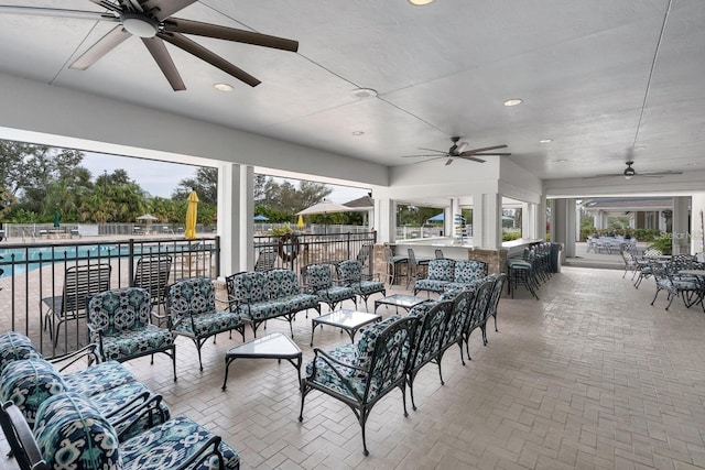 view of patio / terrace featuring outdoor lounge area, a bar, and a community pool