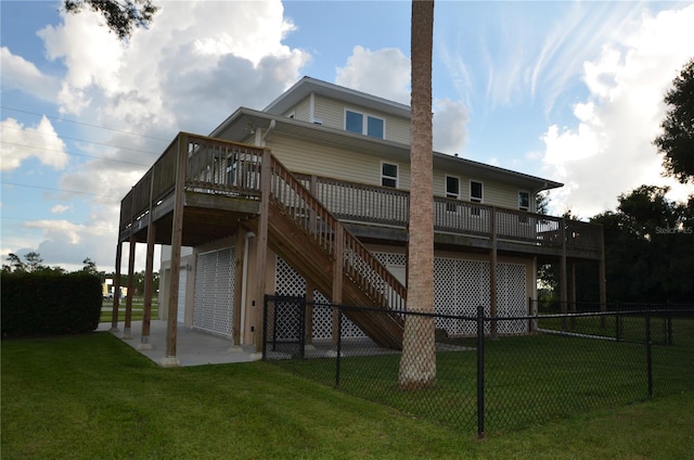 rear view of house with a deck, a yard, and a patio