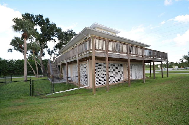 back of property with a deck and a yard