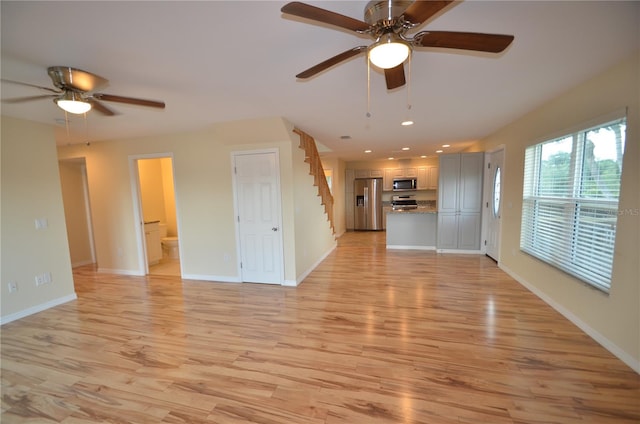 unfurnished living room featuring light hardwood / wood-style flooring and ceiling fan