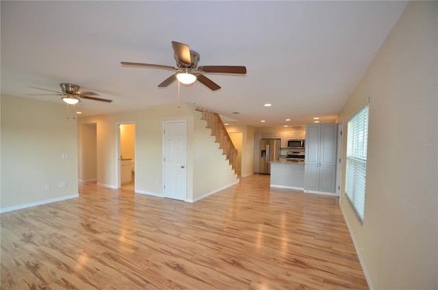 unfurnished living room featuring ceiling fan and light hardwood / wood-style flooring