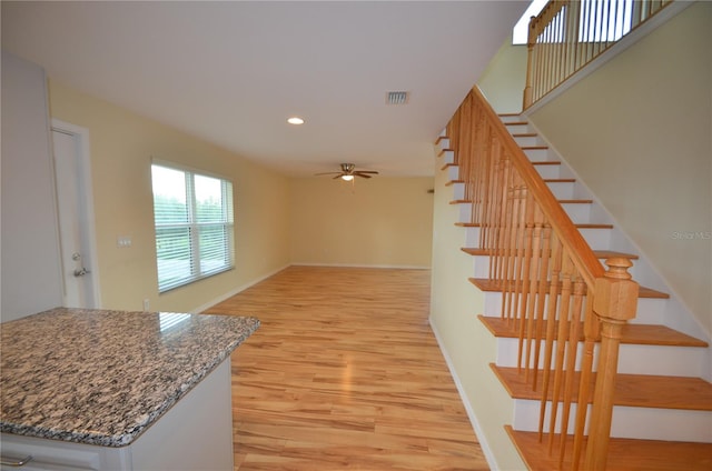 stairway featuring ceiling fan and hardwood / wood-style flooring