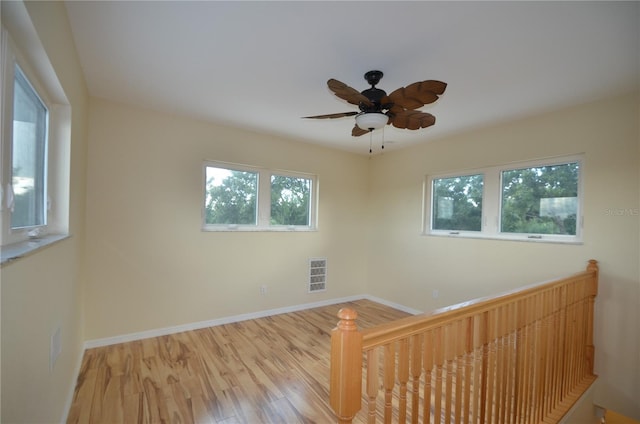 unfurnished room with ceiling fan, light hardwood / wood-style floors, and a wealth of natural light