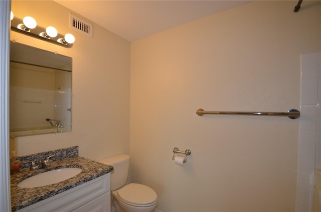 bathroom with walk in shower, vanity, and toilet