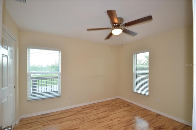 spare room with ceiling fan and light wood-type flooring