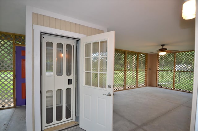 doorway to outside with ceiling fan, concrete flooring, and a wealth of natural light