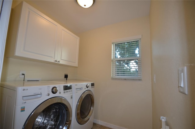 laundry room featuring washer and dryer and cabinets