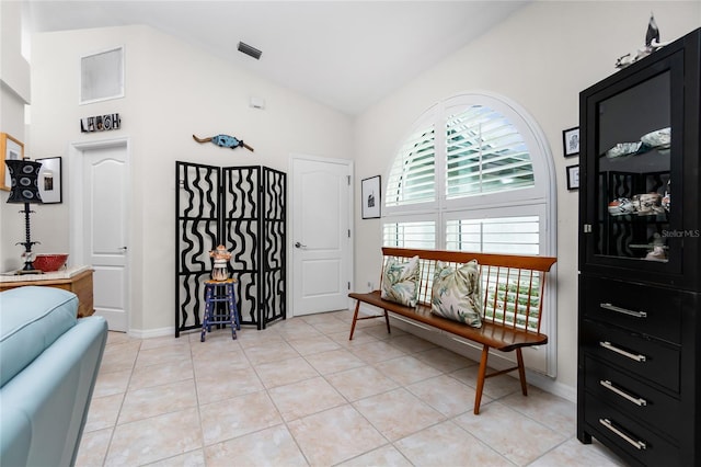 sitting room with lofted ceiling and light tile patterned floors