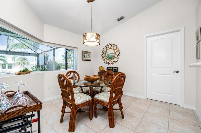 tiled dining room featuring vaulted ceiling