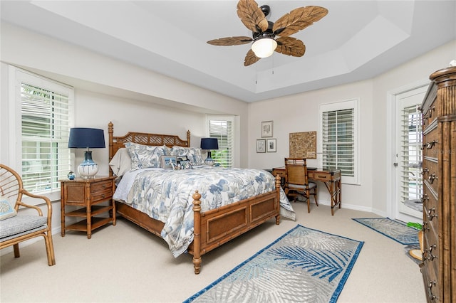 bedroom featuring ceiling fan, a raised ceiling, and carpet