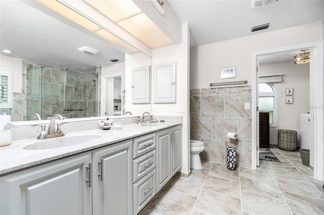 bathroom featuring vanity, tile walls, toilet, and tiled shower