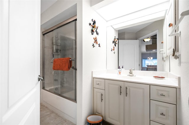 bathroom with tile patterned floors, vanity, and bath / shower combo with glass door