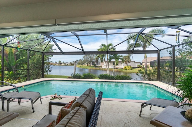 view of swimming pool with a water view, a patio area, and glass enclosure