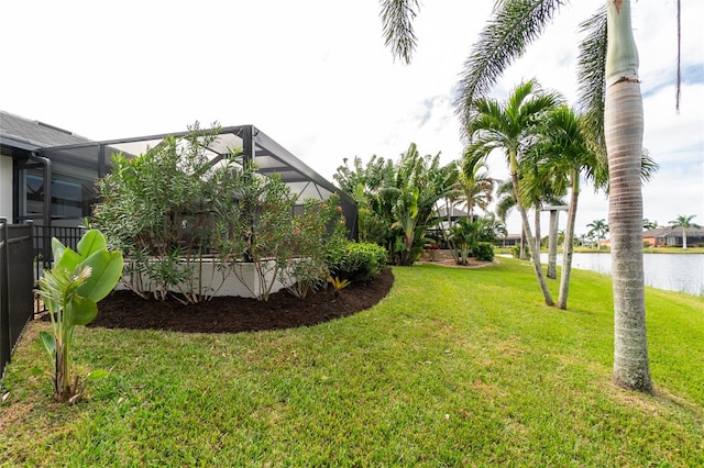 view of yard with a water view and a lanai