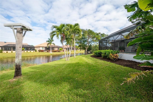 view of yard with glass enclosure and a water view