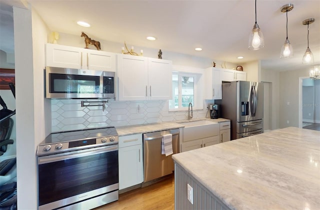 kitchen featuring appliances with stainless steel finishes, white cabinetry, and sink