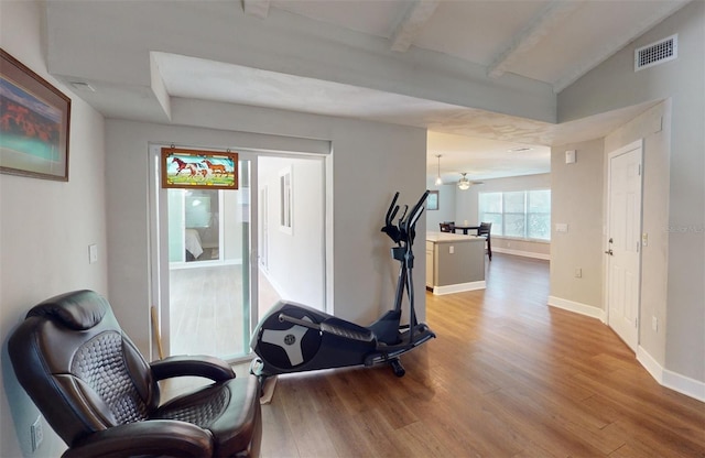 workout area with lofted ceiling, ceiling fan, and light hardwood / wood-style floors