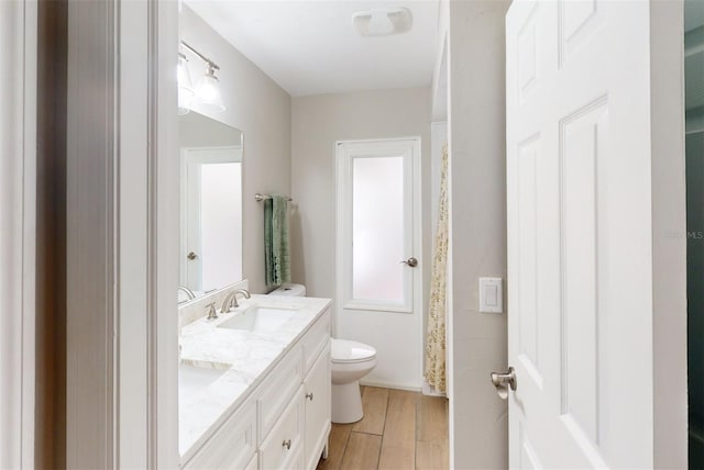 bathroom with vanity, toilet, and hardwood / wood-style flooring