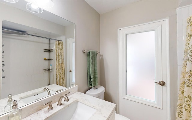 bathroom with vanity, toilet, and curtained shower