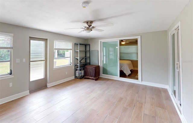 spare room featuring a wealth of natural light, ceiling fan, and light hardwood / wood-style floors