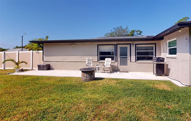 rear view of house with a lawn and a patio area