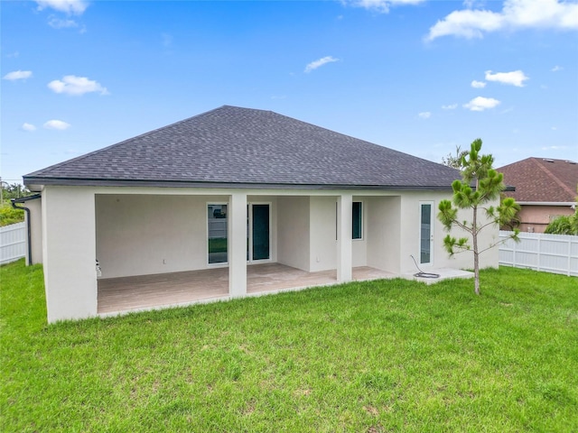 back of house with a lawn and a patio area