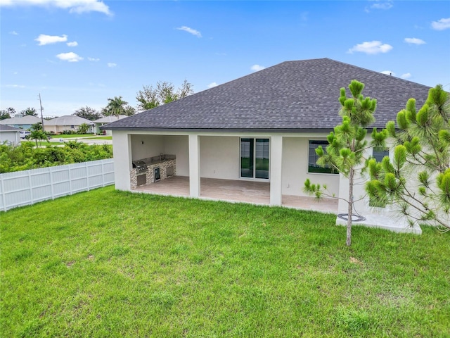 back of house with a lawn, a patio, and exterior kitchen