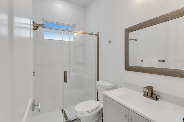 bathroom with vanity, a shower with shower door, and toilet