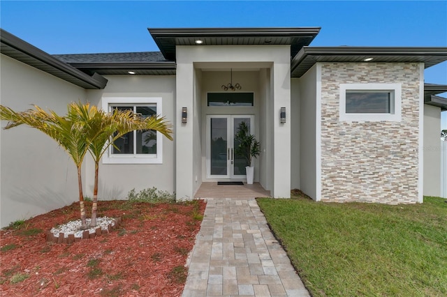 entrance to property featuring french doors and a yard