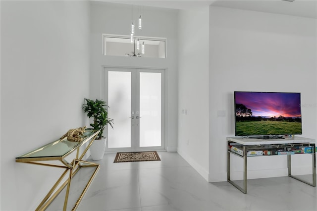 foyer entrance with a chandelier and french doors