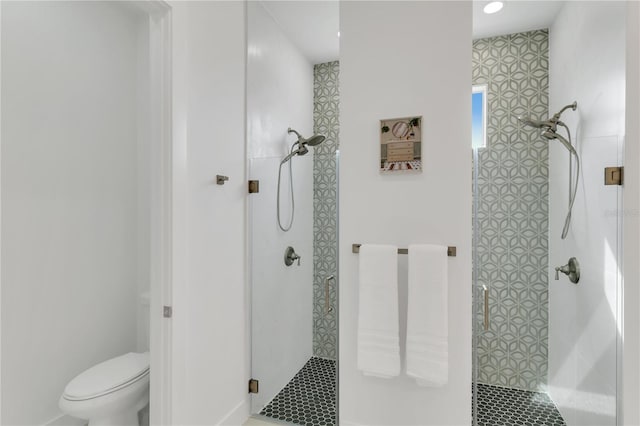 bathroom with a shower with shower door and toilet