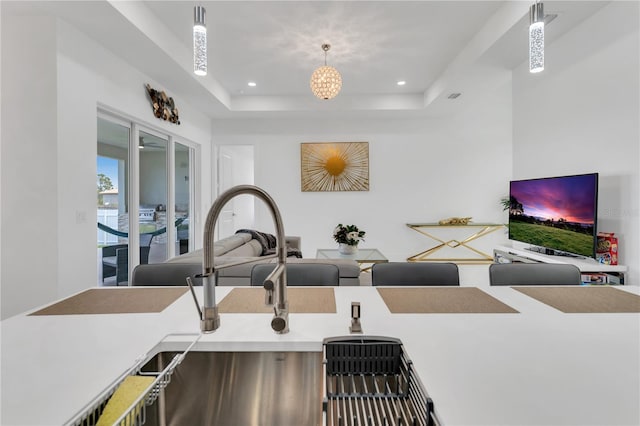 kitchen featuring a tray ceiling and hanging light fixtures