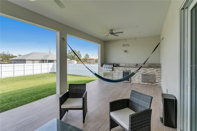 view of patio / terrace with grilling area, ceiling fan, and exterior kitchen