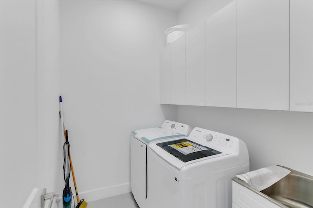 washroom with separate washer and dryer and cabinets