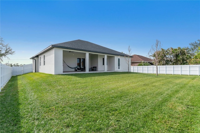 rear view of house featuring a yard and a patio